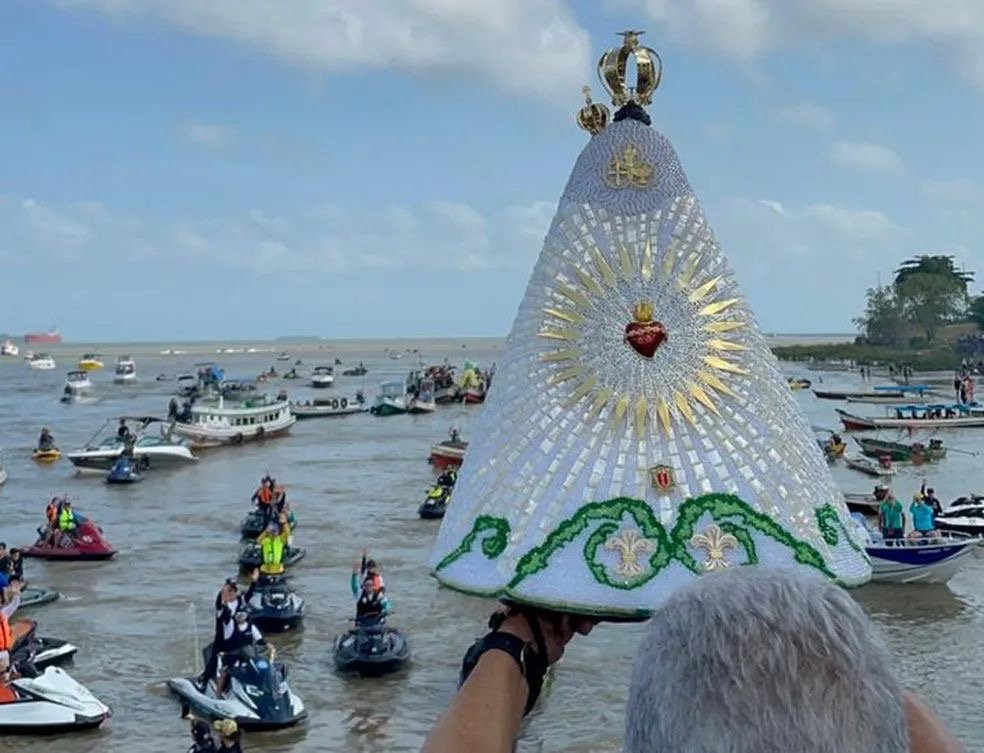 Imagem de Nossa Senhora de Nazaré durante o Círio Fluvial com barcos ao fundo